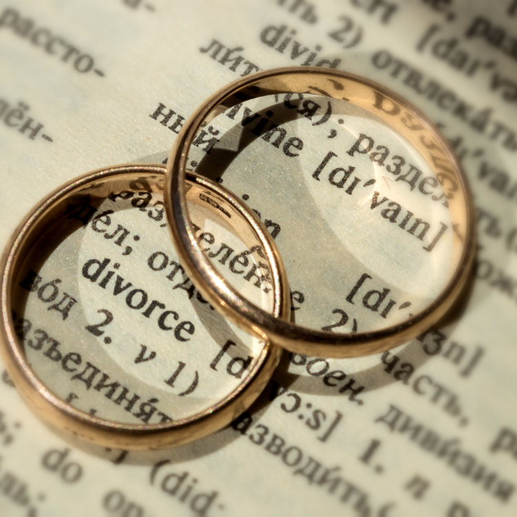 two wedding rings on top of the word divorce