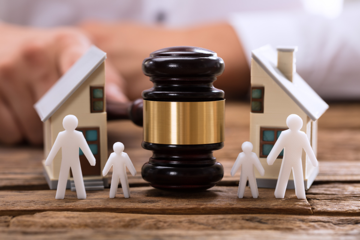 a mallet with a figure of a separated family - a concept of child support during divorce