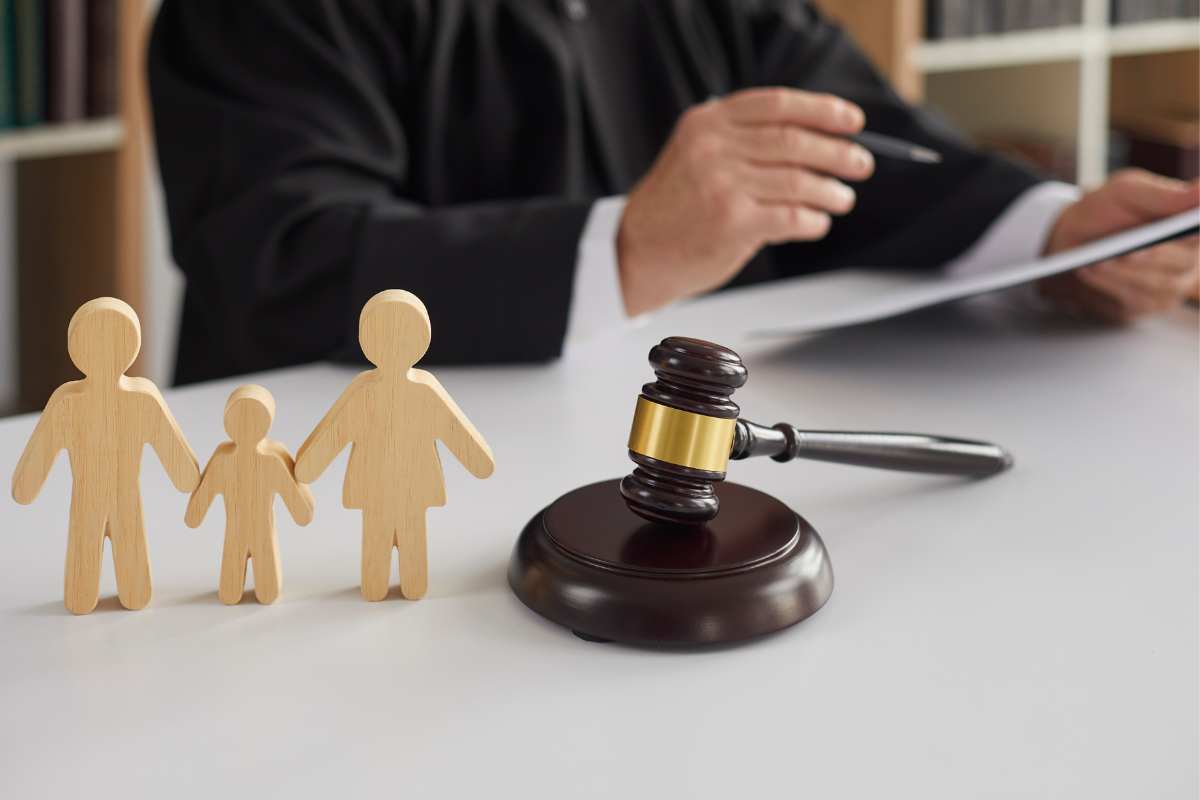 wooden figurine of a family with a child and gavel - representing child support lawyer