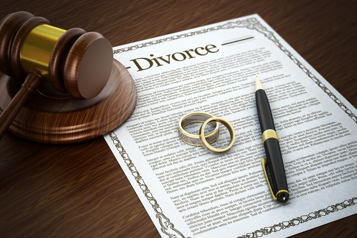 divorce decree document, gavel, pen, and wedding rings - representing contested divorce